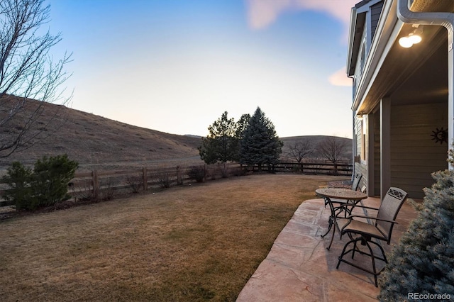 view of yard featuring a patio, a fenced backyard, and a mountain view