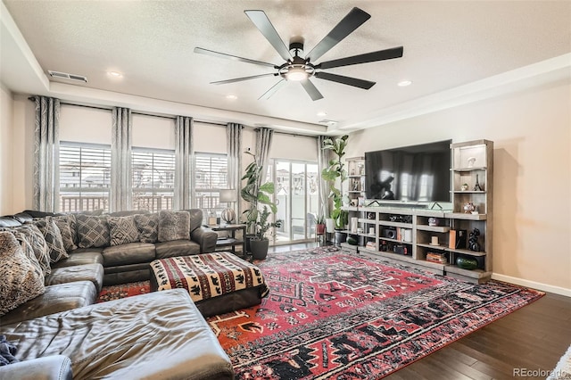 living room with ceiling fan, wood-type flooring, and a textured ceiling