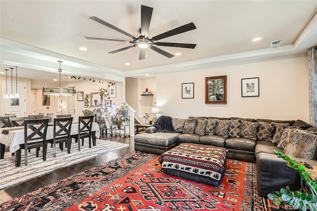 living room featuring ceiling fan, a tray ceiling, and hardwood / wood-style floors