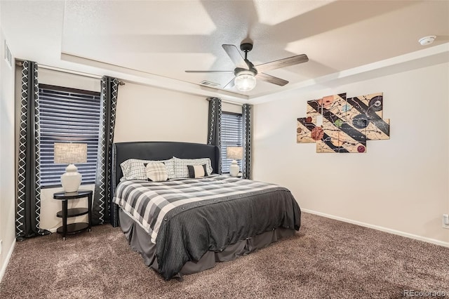 bedroom with a raised ceiling, ceiling fan, a textured ceiling, and dark carpet