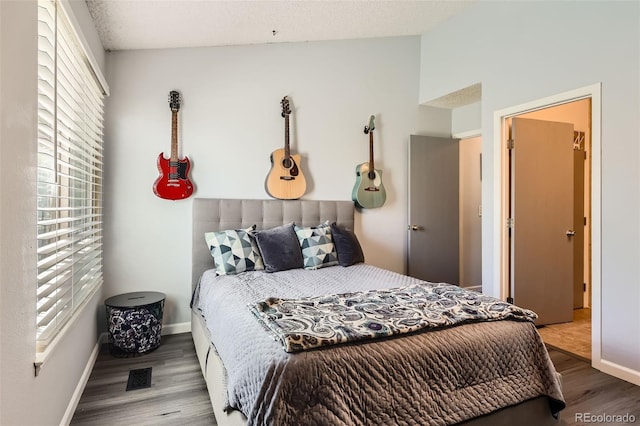 bedroom featuring baseboards, wood finished floors, multiple windows, and visible vents