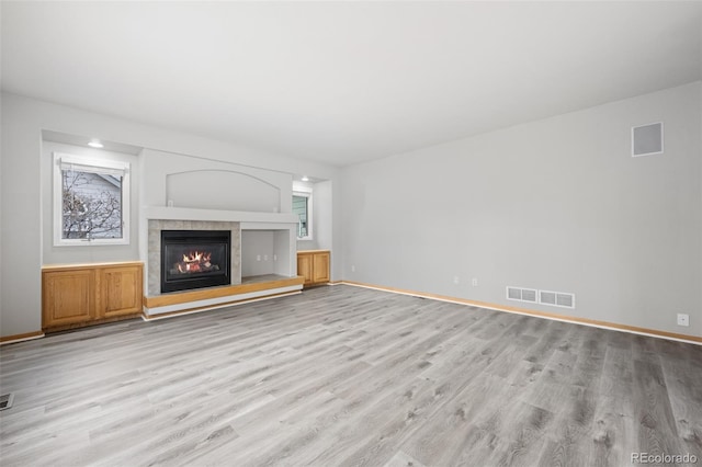 unfurnished living room with a fireplace and light hardwood / wood-style floors