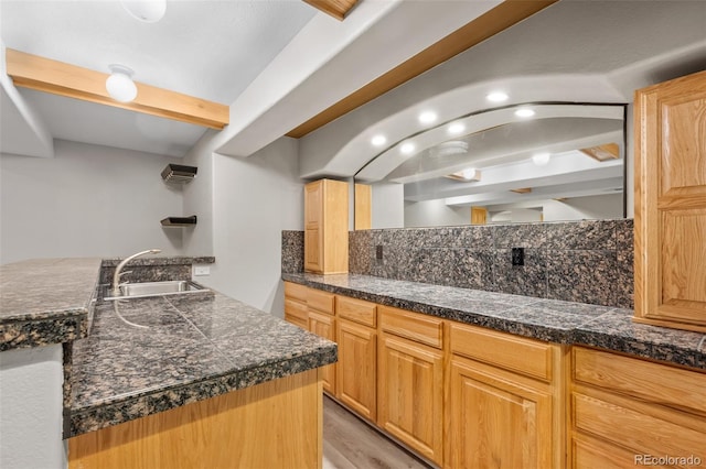 kitchen featuring beam ceiling, sink, decorative backsplash, and light hardwood / wood-style flooring