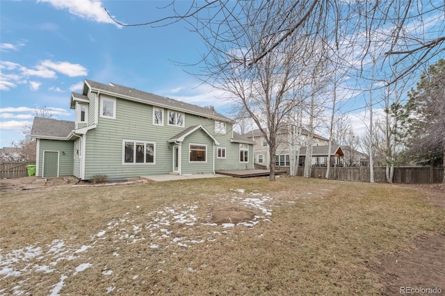 back of property featuring a wooden deck and a lawn