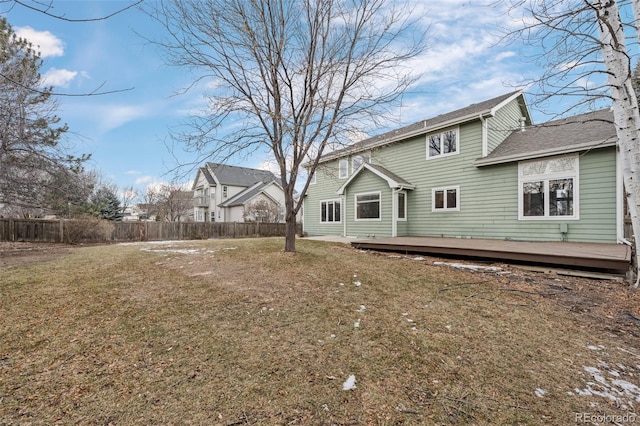 rear view of house with a wooden deck and a yard