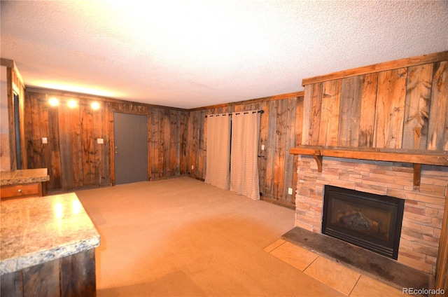 107 Peaks View Ct Unit 324, Blue River, CO 80424 - unfurnished living room with wood walls, a fireplace, a textured ceiling, and carpet floors
