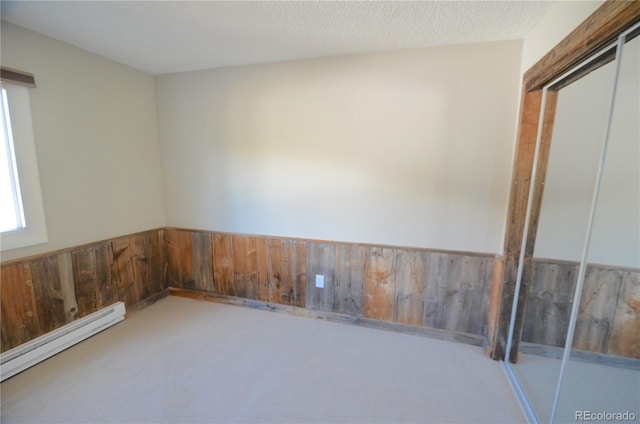 107 Peaks View Ct Unit 324, Blue River, CO 80424 - empty room with baseboard heating, wainscoting, carpet flooring, and wooden walls