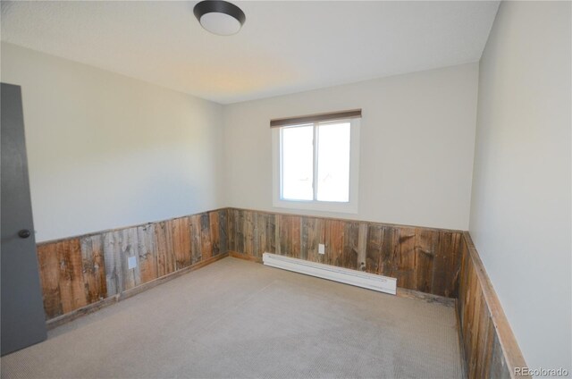 107 Peaks View Ct Unit 324, Blue River, CO 80424 - spare room with baseboard heating, carpet, wooden walls, and a wainscoted wall