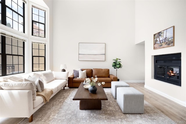 1530 S Quebec Way Unit 24, Denver, CO 80231 - living area with a towering ceiling, wood finished floors, and a glass covered fireplace