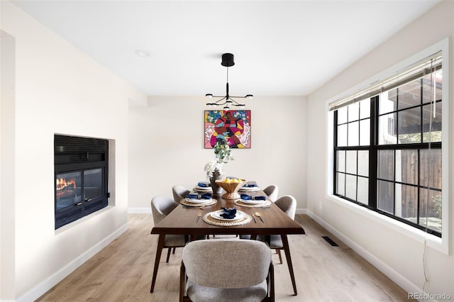 1530 S Quebec Way Unit 24, Denver, CO 80231 - dining space featuring light wood-style floors and a glass covered fireplace