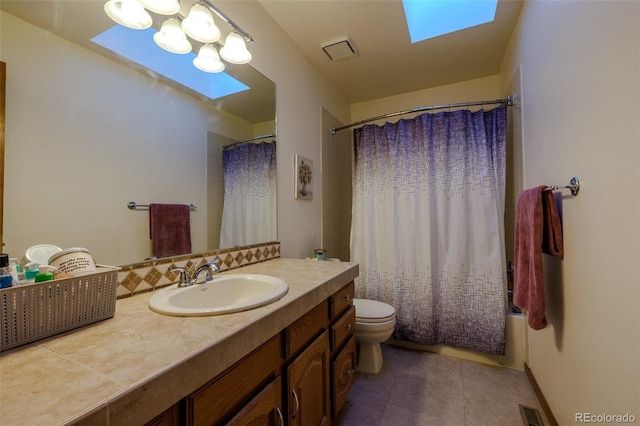 full bathroom with shower / tub combo with curtain, a skylight, vanity, tile patterned floors, and toilet