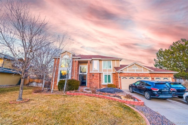 view of front of property with a garage and a lawn