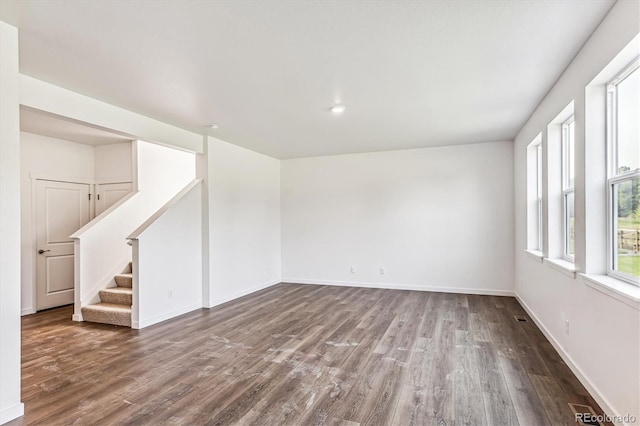 empty room with stairway, baseboards, and wood finished floors