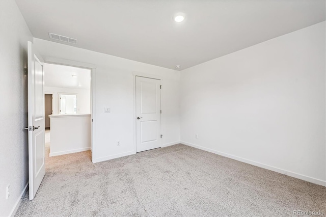 unfurnished bedroom featuring light carpet, visible vents, and baseboards