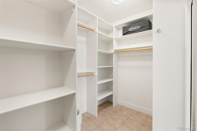 walk in closet with light tile patterned floors