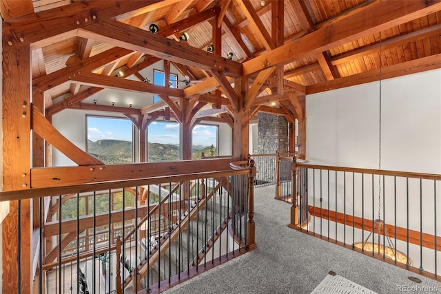 hallway with lofted ceiling with beams, wood ceiling, a mountain view, and carpet floors