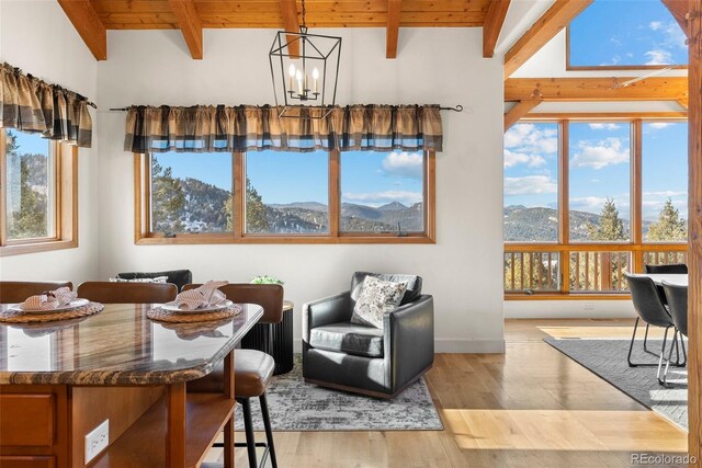 13326 Kuehster Rd, Littleton, CO 80127 - dining room featuring a chandelier, wood ceiling with exposed beams, light wood finished floors, and a mountain view