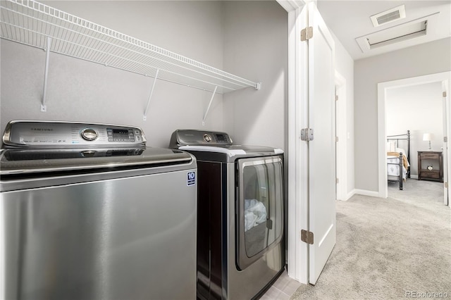 laundry room with separate washer and dryer and light colored carpet