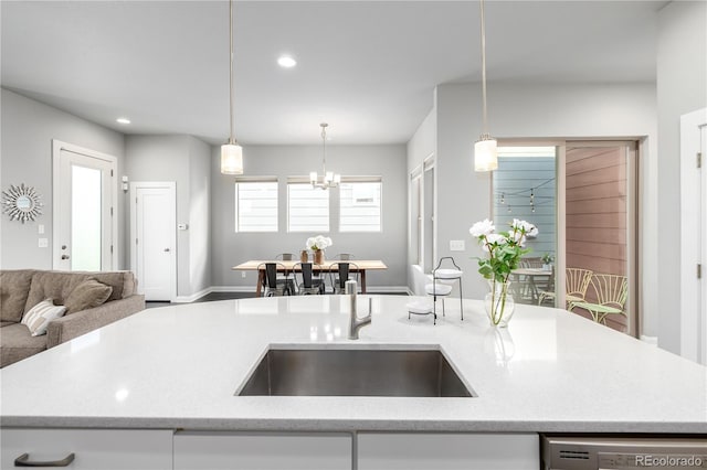 kitchen featuring dishwasher, an island with sink, and pendant lighting