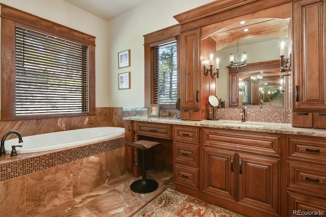 bathroom with an inviting chandelier, a relaxing tiled bath, vanity, backsplash, and tile floors