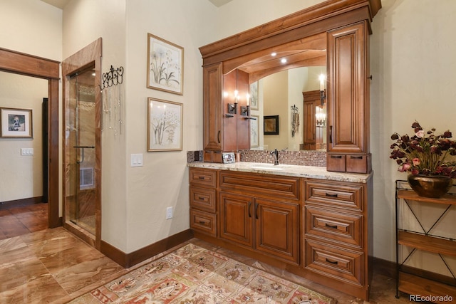 bathroom with an enclosed shower, vanity, and tile flooring