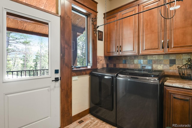 laundry room featuring washing machine and clothes dryer, cabinets, and hookup for a washing machine