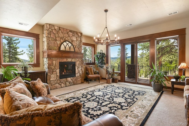 living room with a notable chandelier and a stone fireplace