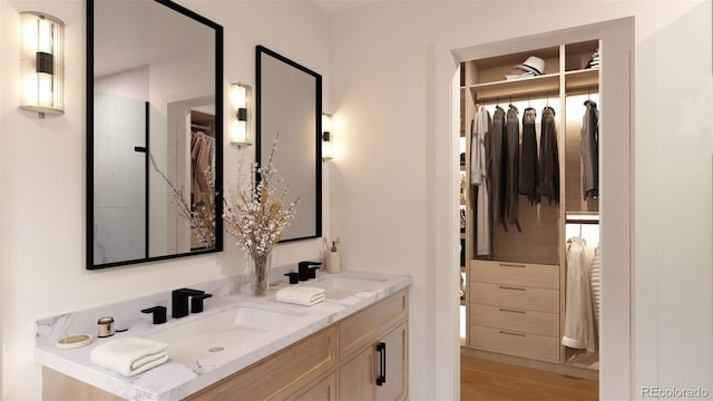 32778 Janelle Ln, Golden, CO 80403 - bathroom featuring double vanity, a sink, a spacious closet, and wood finished floors