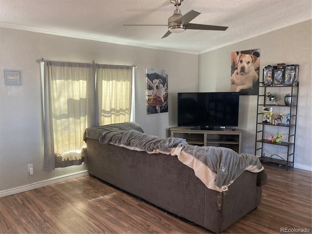 living room featuring a textured ceiling, ceiling fan, ornamental molding, and dark wood-type flooring