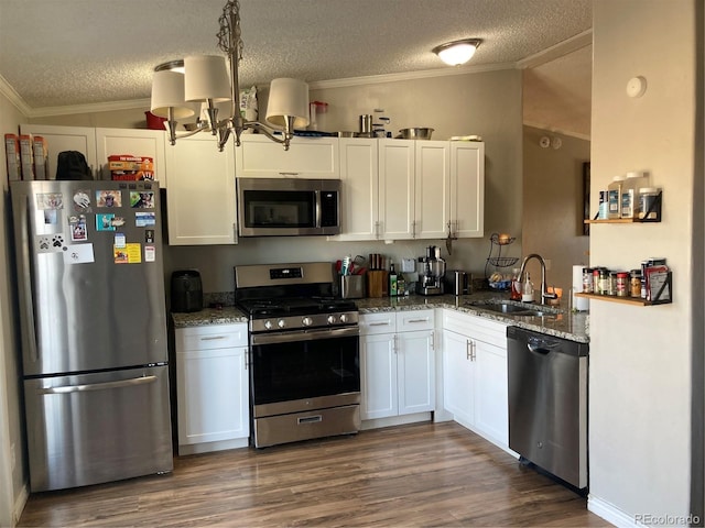 1103 Stage Dr, Fort Lupton, CO 80621 - kitchen featuring stainless steel appliances, dark stone counters, a textured ceiling, crown molding, and white cabinets