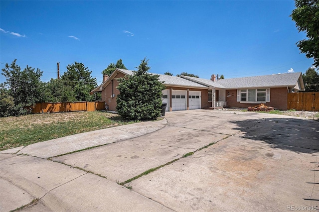 3306 S Uinta Ct, Denver, CO 80231 - view of front facade with a garage, brick siding, concrete driveway, and a chimney