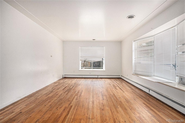 3306 S Uinta Ct, Denver, CO 80231 - empty room featuring baseboard heating, hardwood / wood-style flooring, healthy amount of natural light, and a baseboard radiator
