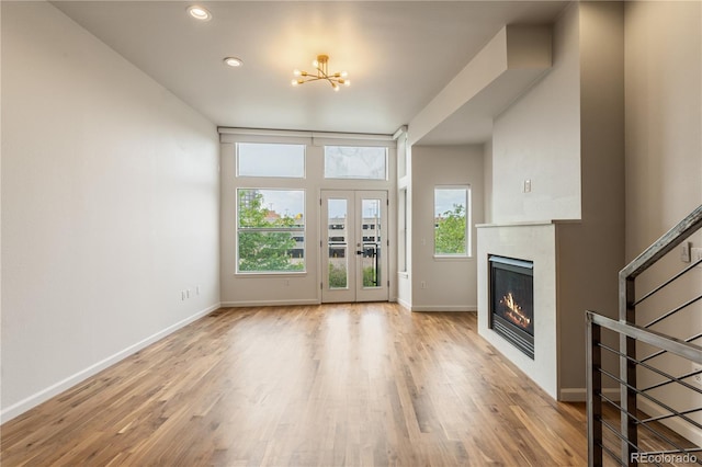 2680 Blake St Unit 4, Denver, CO 80205 - unfurnished living room with a glass covered fireplace, wood finished floors, stairs, a chandelier, and recessed lighting