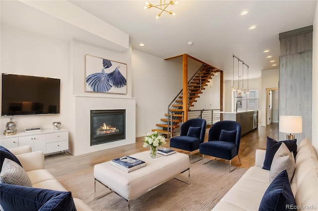 2680 Blake St Unit 4, Denver, CO 80205 - living area with a chandelier, a glass covered fireplace, light wood finished floors, recessed lighting, and stairs