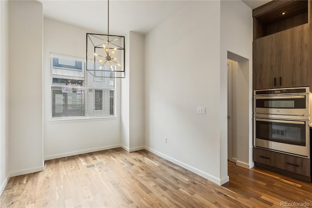 2680 Blake St Unit 4, Denver, CO 80205 - unfurnished dining area featuring wood finished floors and a chandelier