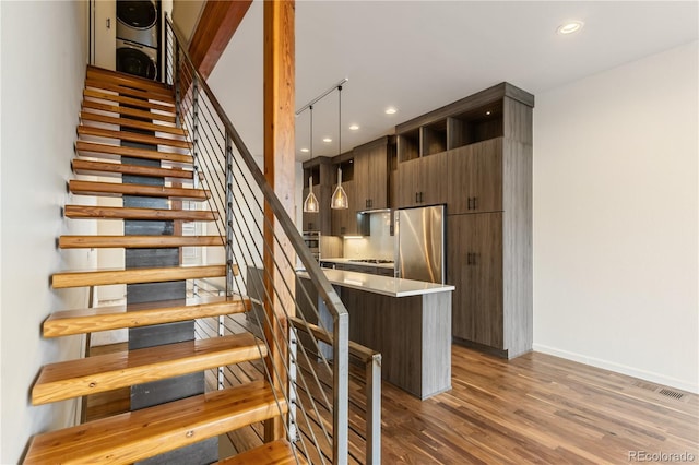 2680 Blake St Unit 4, Denver, CO 80205 - stairway featuring estacked washer and dryer, wood finished floors, and recessed lighting