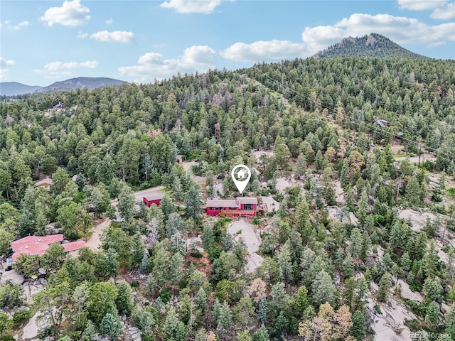 8940 S Brandenburger Dr, Morrison, CO 80465 - aerial view of property and surrounding area featuring a heavily wooded area and mountains