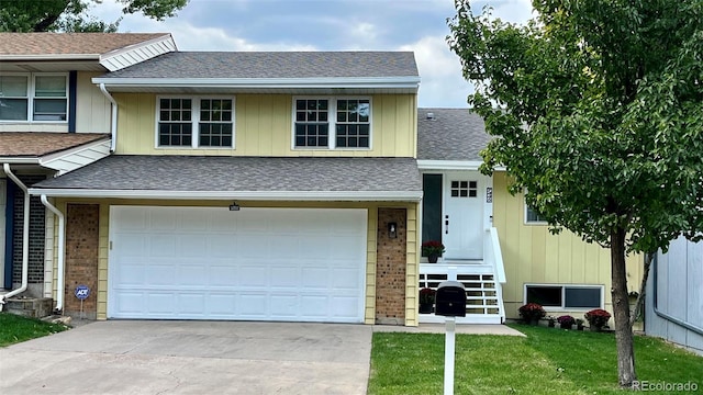 tri-level home featuring a garage and a front lawn