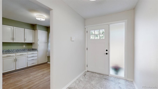 foyer with a textured ceiling and light hardwood / wood-style floors