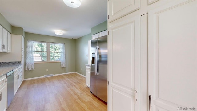 kitchen with appliances with stainless steel finishes, light wood-type flooring, and white cabinetry