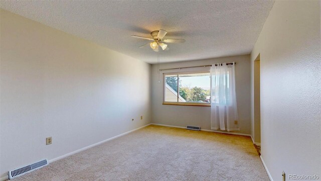 carpeted empty room with a textured ceiling and ceiling fan