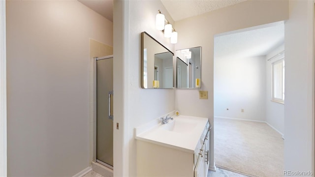 bathroom featuring vanity, a textured ceiling, and a shower with door