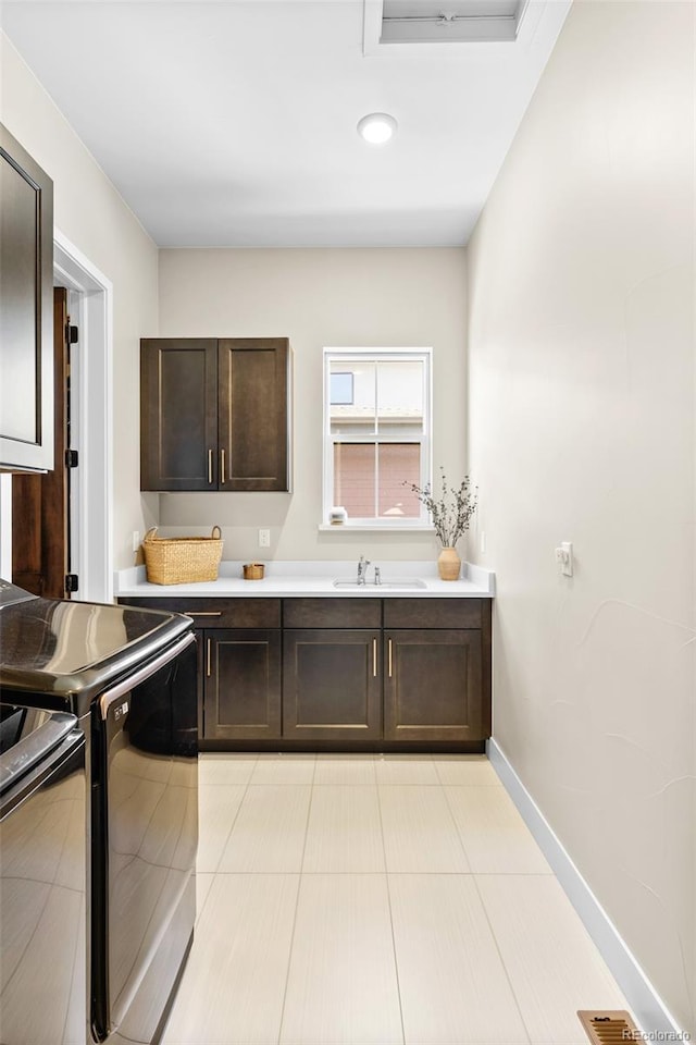 6589 Canyonpoint Rd, Castle Pines, CO 80108 - kitchen with stove, light countertops, dark brown cabinetry, and a sink