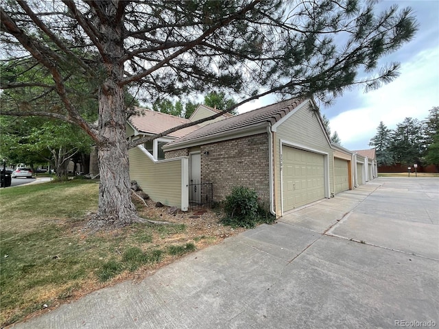 view of property exterior featuring a garage and a yard