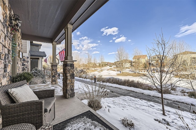 snow covered patio featuring a porch