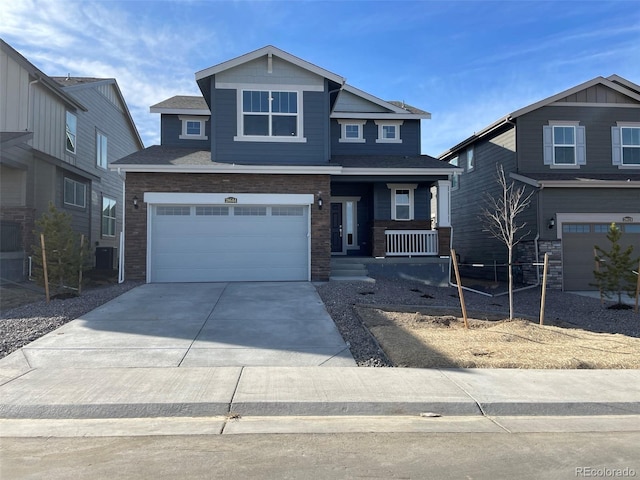 craftsman inspired home with a garage, covered porch, and concrete driveway