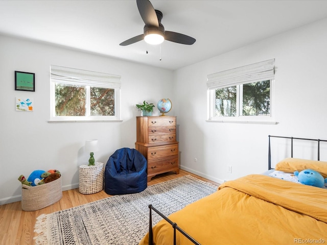 bedroom with baseboards, wood finished floors, and ceiling fan