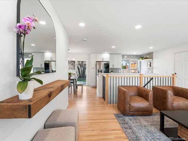 living room with light wood-style flooring and recessed lighting