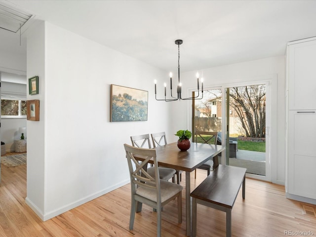 dining area with a healthy amount of sunlight, attic access, baseboards, and light wood-style floors