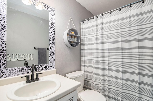 full bath with toilet, a textured wall, and vanity